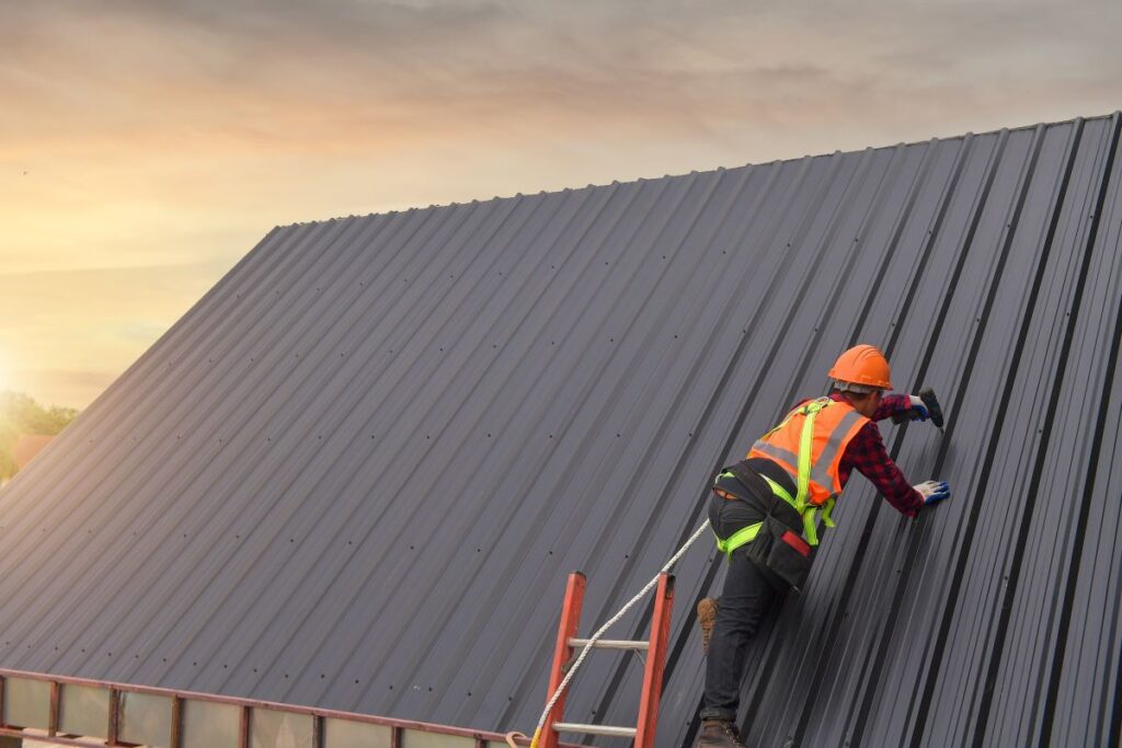 roofer inspecting and repairing metal roof