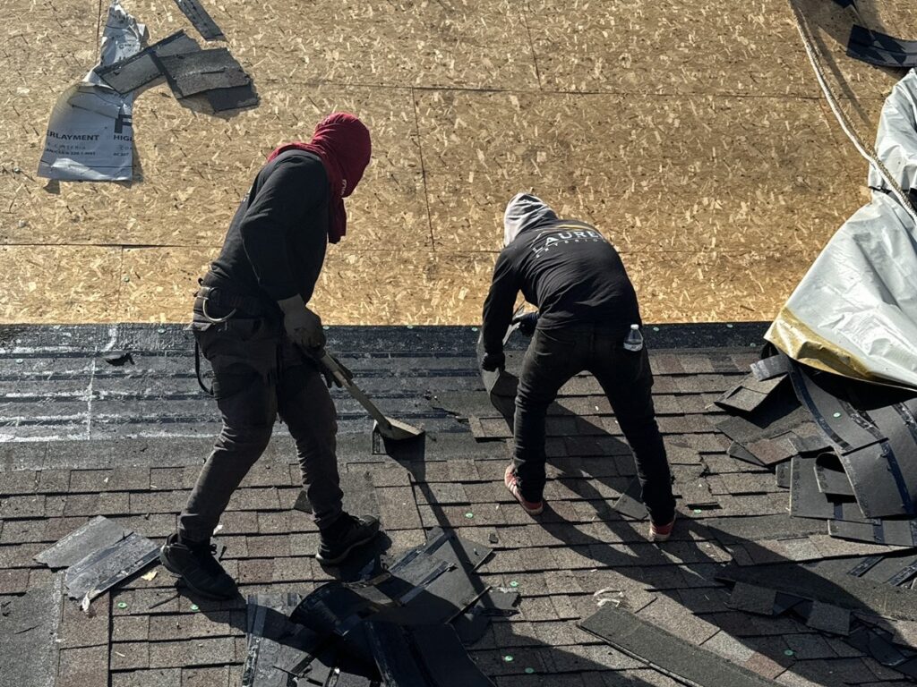 roofers using a tool to remove shingles