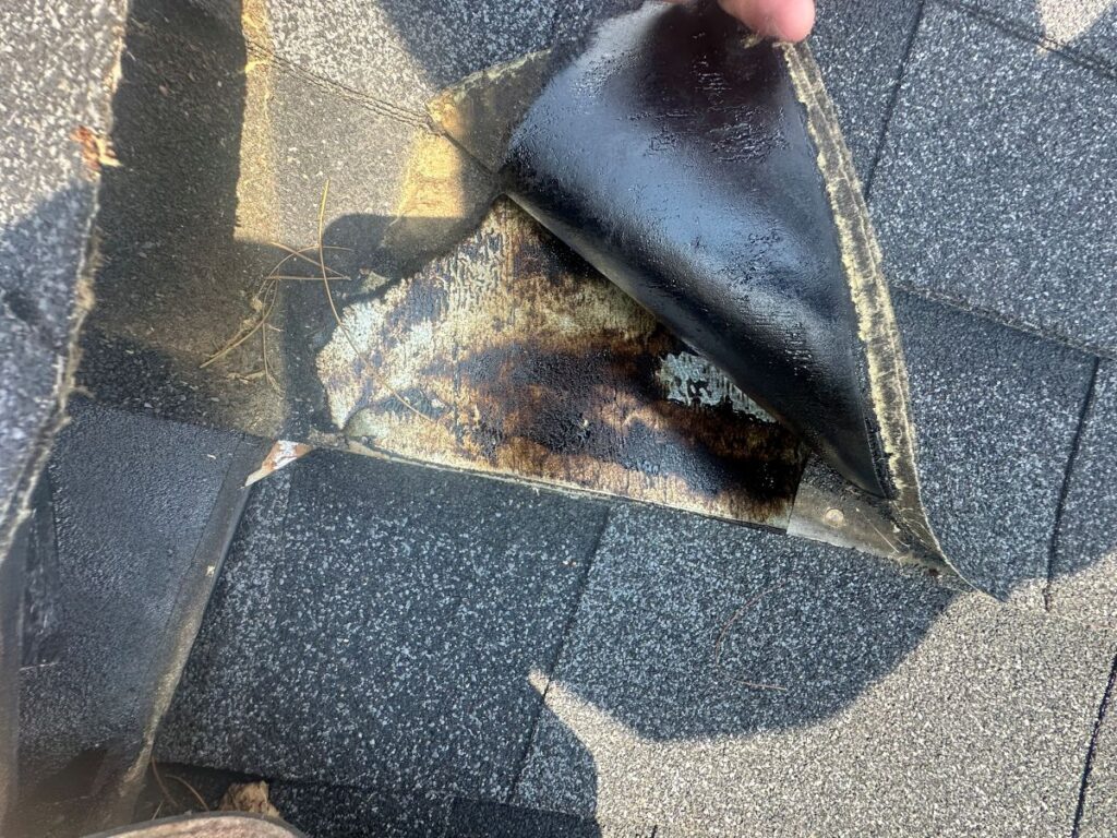 hand lifting up a damaged and loose shingle