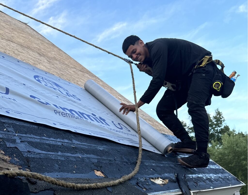 Lauren Exteriors' roofer using a safety harness on a roof